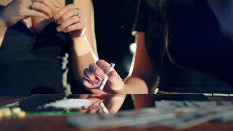 Two girls snorting an illegal white powder with dollar bills off a mirror. Stock Footage 87129205