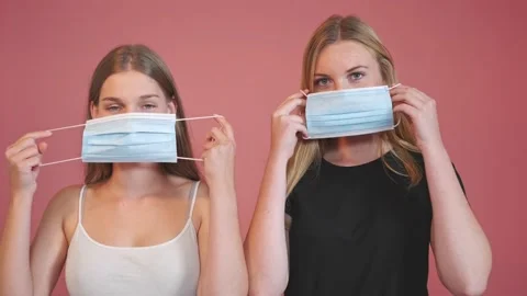 Two girls standing in front of the camera while putting a face mask Stock Footage 138958515