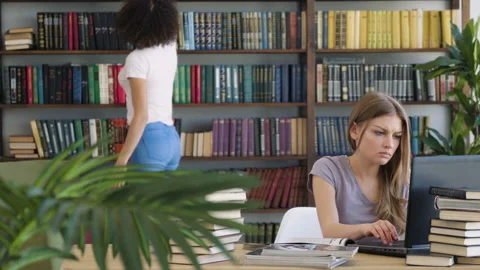 Two girls study by book laptop Stock Footage 89649064