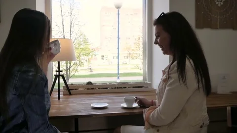 Two girls talking in the coffee Stock Footage 75809226