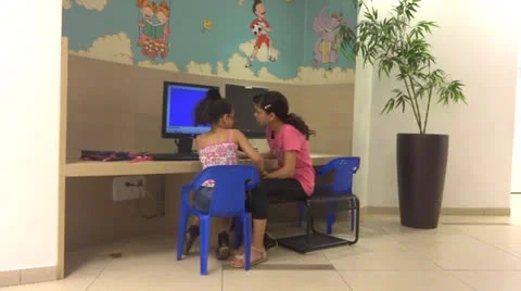 Two girls talking by computer Stockbeeldmateriaal 24839402