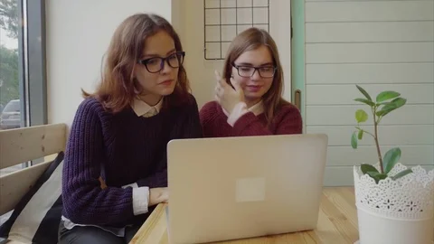 Two girls talking to friends via webchat or having a video chat in cafe Stock Footage 70682700