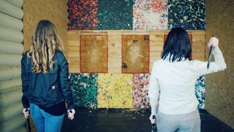 Two girls throw axes at the target Stock Footage 81924879