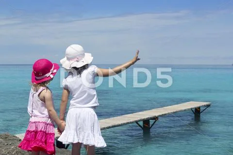Two girls tourist turquoise sea goodbye hand gesture Stock Photos