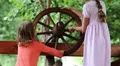 Two girls turn wooden wheel HD Footage