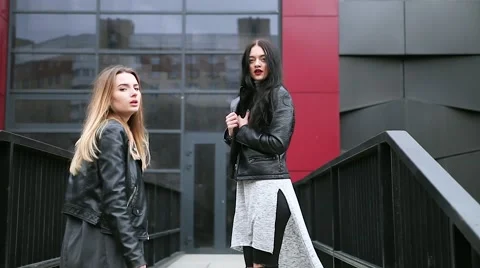 Two girls walking on the street, looking at the camera and smiling Stock Footage