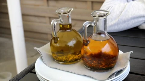 Two glass bottles of infused olive oil with herbs on a restaurant table, ru.. Stock Footage 307619782