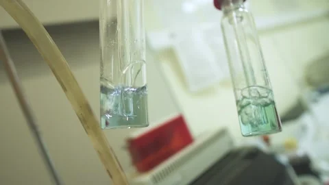 Two glass tubes boiling in laboratory. Chemical analysis takes place through Stock Footage 153863724