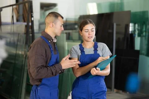Two glass workshop workers discussing documents 스톡 사진