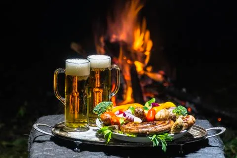 Two glasses of beer on the background of fire Stock Photos