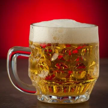 Two glasses of beer on a stone table over red background Stock Photos