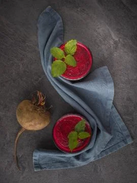 Two glasses of beetroot smoothie with mint leaves on dark table. Overhead Stock Photos