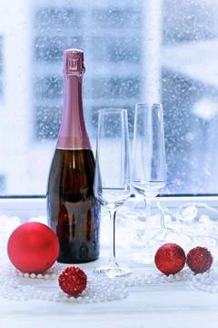 Two glasses, a bottle of rose sparkling wine and Christmas-tree decorations Stock Photos