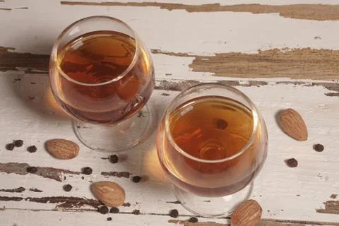 Two glasses of brandy on pine surface. Stock Photos