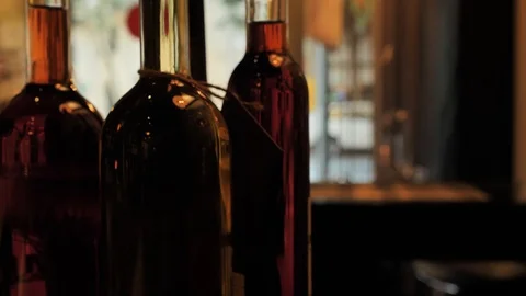 Two glasses of champagne and different colors bottles of wine exhibition in the Stock Footage 92306726