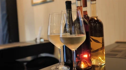 Two glasses of champagne and different colors bottles of wine exhibition in the Stock Footage 92307141