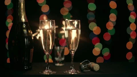 Two glasses of champagne on the background of burning sparkler Stock Footage 81322850