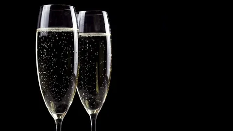 Two glasses of champagne with bubbles on black background. Stock Footage