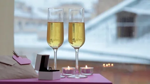 Two glasses of champagne, ring in box and note with heart in winter Stock Footage 69222553