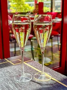 Two glasses of champagne side by side on a table in a restaurant Stock Photos
