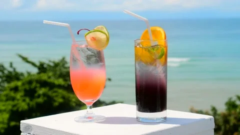 Two glasses of chilled non-alcoholic tasty tropical cocktails with ocean Video stock 182032484