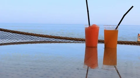 Two glasses of cocktail stand on a table in a bar near the seashore Stock Footage 114325567