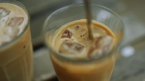 Two glasses of coffee with ice cubes in them Stock-Footage 297951393