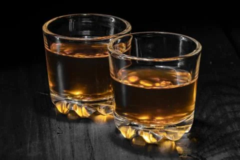 Two glasses of cognac on a black tree Stock Photos