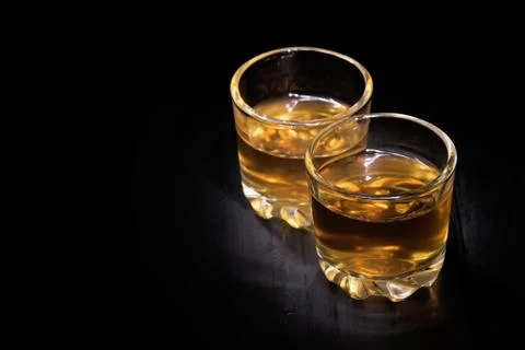 Two glasses of cognac on a black tree Stock Photos