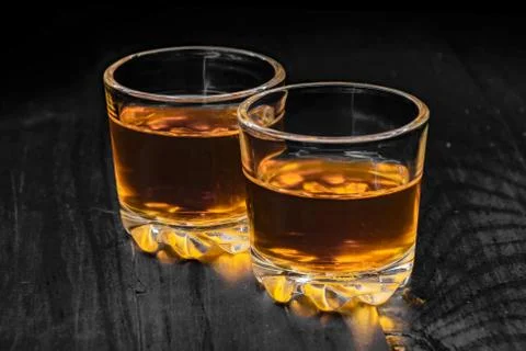 Two glasses of cognac on a black tree Stock Photos