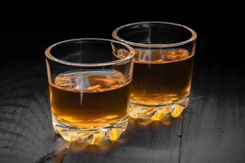 Two glasses of cognac on a black tree Stock Photos