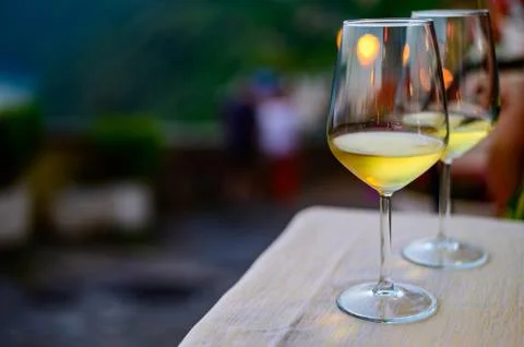 Two glasses of cold dry white wine served outdoor in cafe at night in Italy Stock Photos