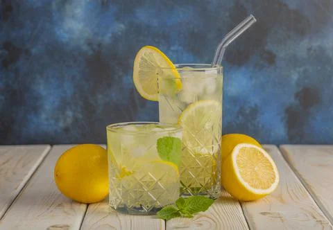 Two glasses of cold, refreshing lemonade. Mojito cocktail with lemon and mint Stock Photos
