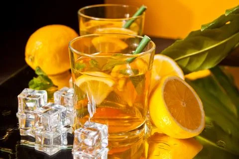 Two glasses of cold refreshment tea with ice and lemon fruit. Stock Photos