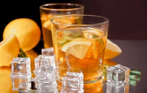 Two glasses of cold refreshment tea with ice and lemon fruit. Stock Photos