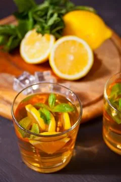 Two glasses of cold refreshment tea with ice and lemon fruit. Stock Photos