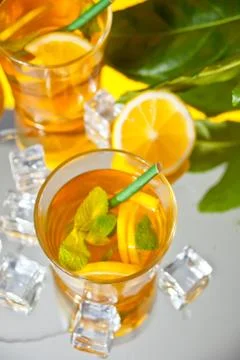 Two glasses of cold refreshment tea with ice and lemon fruit. Stock Photos