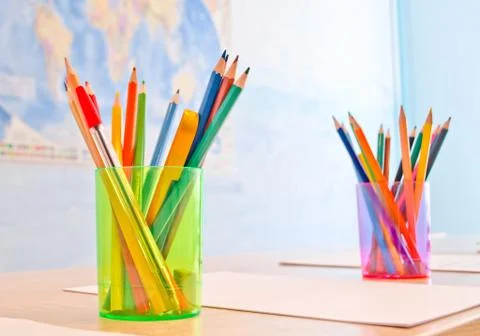 Two glasses with colored pencils that stand on the desk Stock Photos