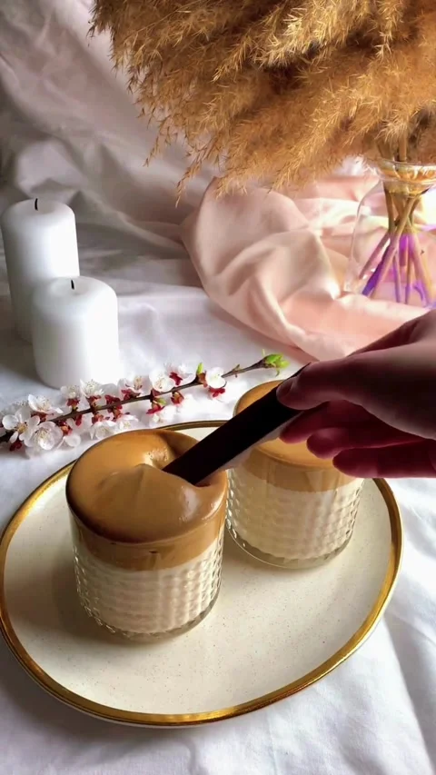 Two glasses of creamy Dalgona coffee on a white plate Video stock 344614787