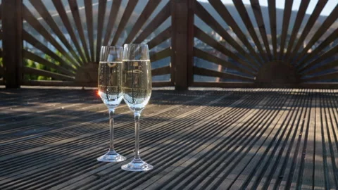 Two glasses on decking floor at sunset Stock Footage 133813194