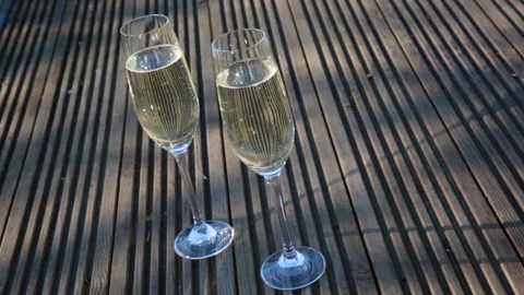 Two glasses on decking floor at sunset Stock Footage 133814603