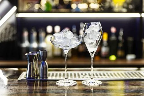 Two glasses of different shapes with ice are on the bar Stock Photos