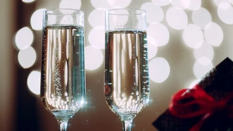 Two glasses filled with champagne and bokeh lights on the background Stock Footage 73922574