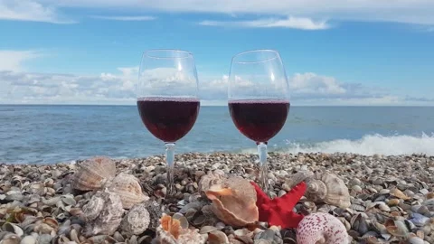 Two glasses filled with red dry wine stand on the shore Stock Footage 156701247