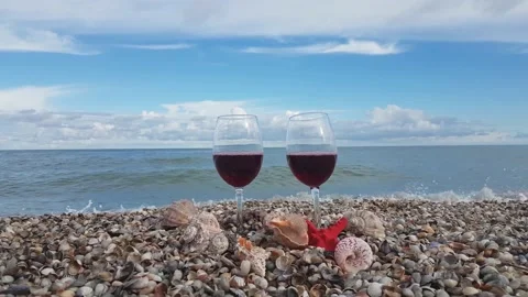 Two glasses filled with red dry wine stand on the shore Stock Footage 156701266