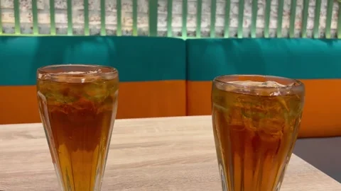 Two Glasses of Fresh Iced Tea on Wooden Table at Modern Cafe Stock Footage 330145217