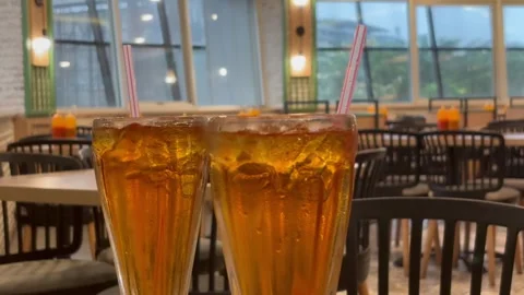 Two Glasses of Fresh Iced Tea with Straws on a Restaurant Table Background Stock Footage 330145236