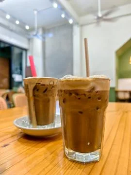 Two glasses of frothy iced pulled milk tea (Teh Tarik) Stock Photos
