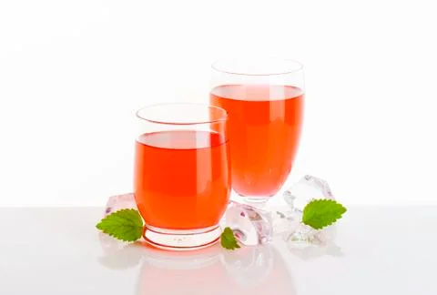 Two glasses of fruit flavored drinks on white background Stock Photos