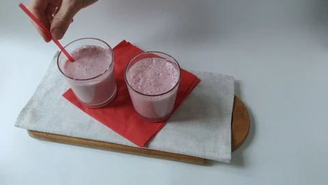 Two glasses fruit smoothies milkshake assembly Stock Footage 109496366